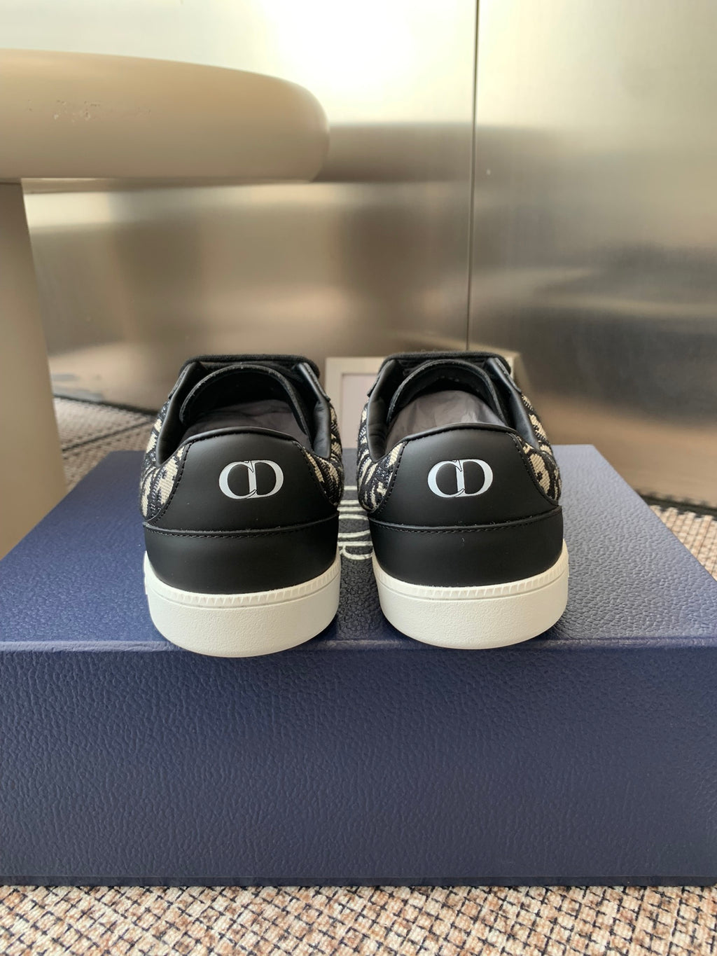 Dior unisex sneakers heel view, black uppers with white rubber midsoles