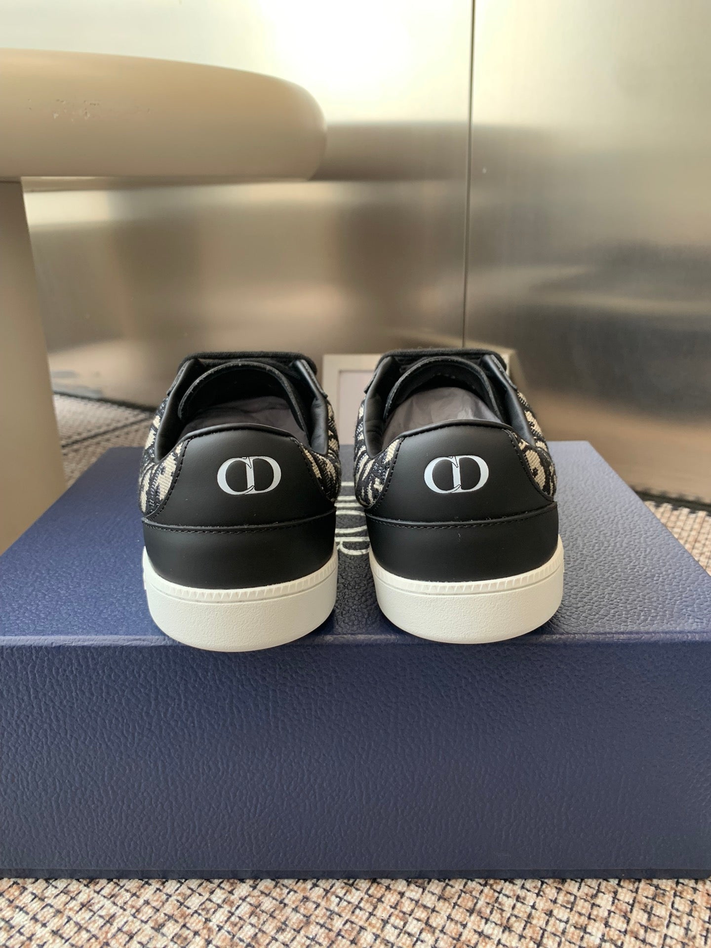 Dior unisex sneakers heel view, black uppers with white rubber midsoles