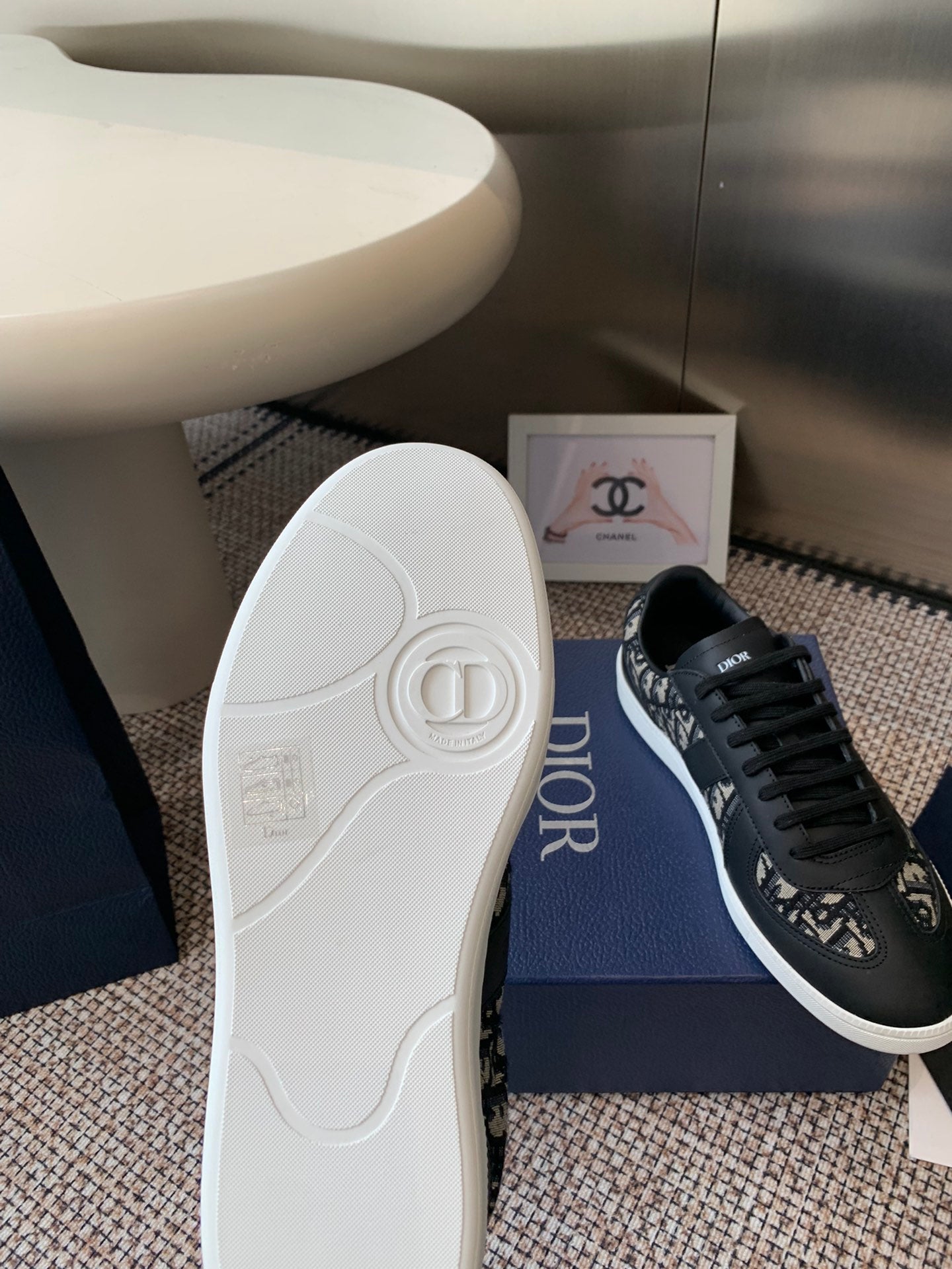 Dior unisex sneaker outsole and side view, white rubber sole on blue box