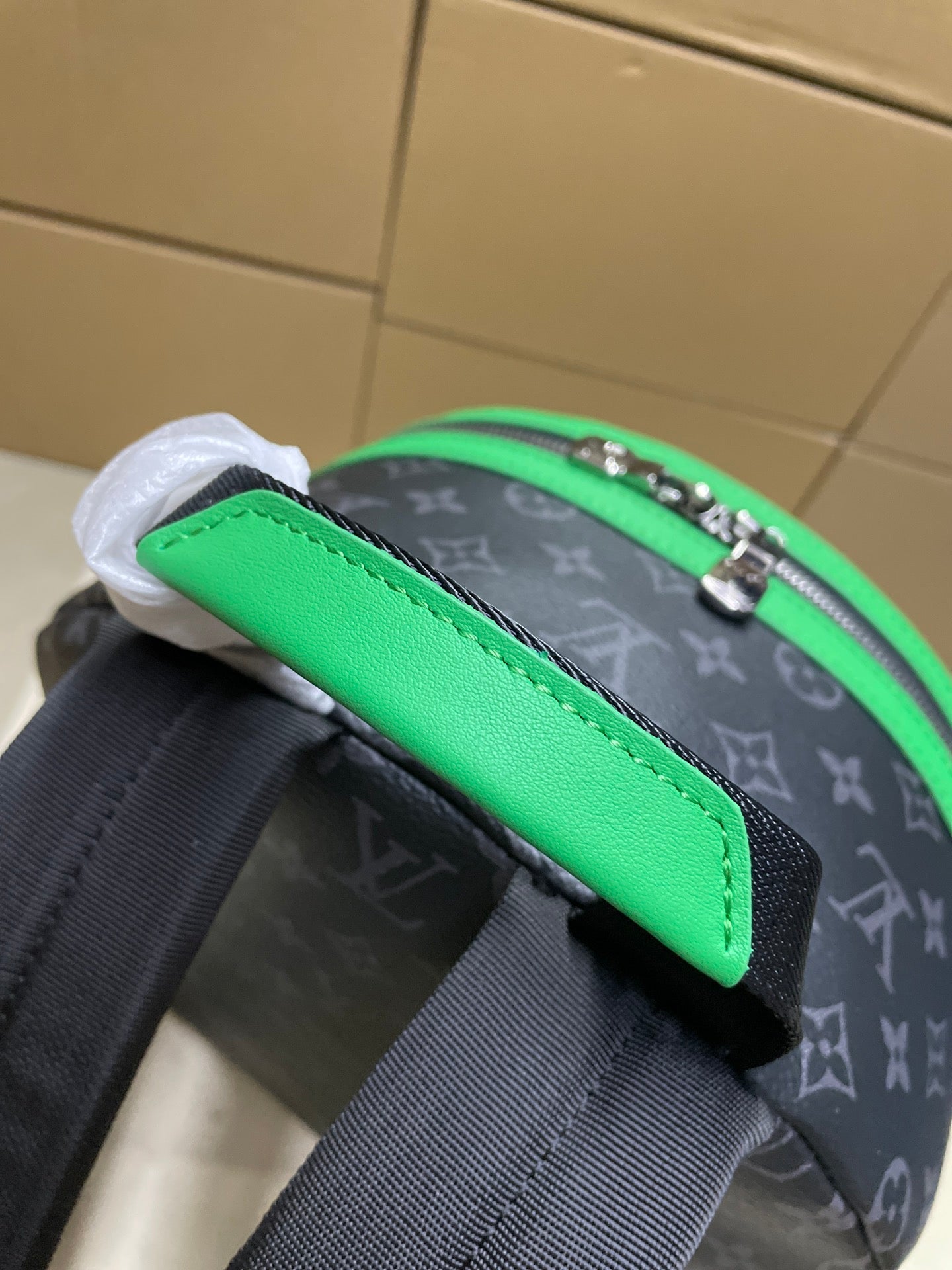 Louis Vuitton mini backpack close-up of green strap panel and monogram