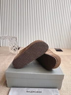 Brown suede sandals with textured rubber outsole, heel side view