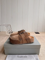 Brown suede mule-style sandals with lace-up front and open top