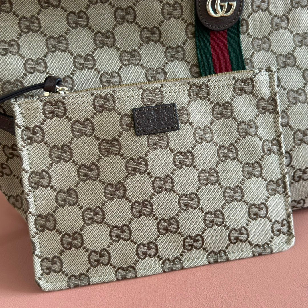 Gucci bag detail: beige GG canvas pouch with black leather patch logo, metal clasp hardware