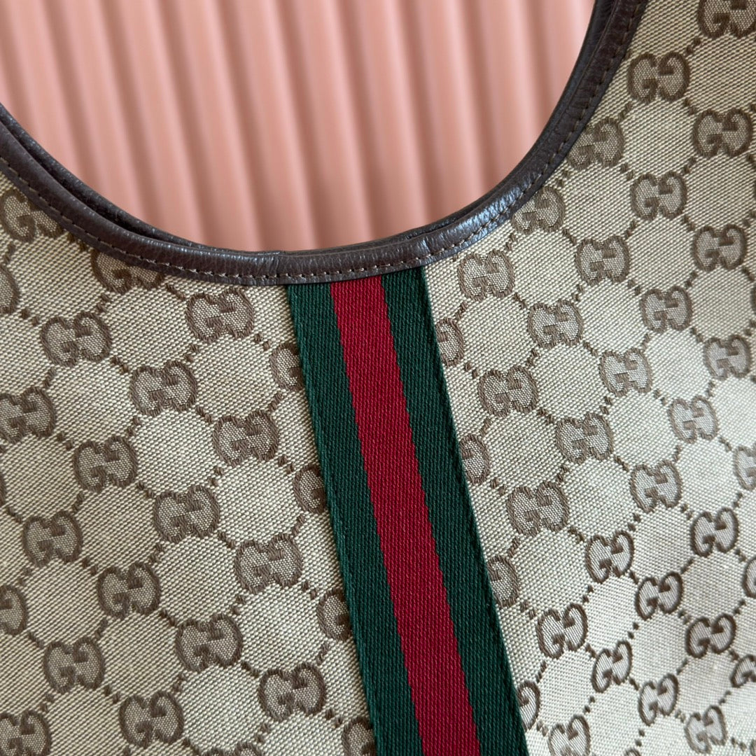 Gucci bag detail: beige GG canvas neckline with green/red web stripe and black leather trim