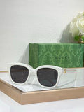 Gucci sunglasses with white frame and dark lenses, gold-toned temple accents.