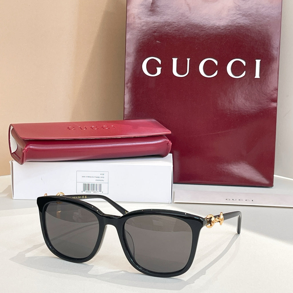 Gucci sunglasses with dark frames and dark brown tinted lenses