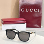 Gucci sunglasses with dark frames and dark brown tinted lenses