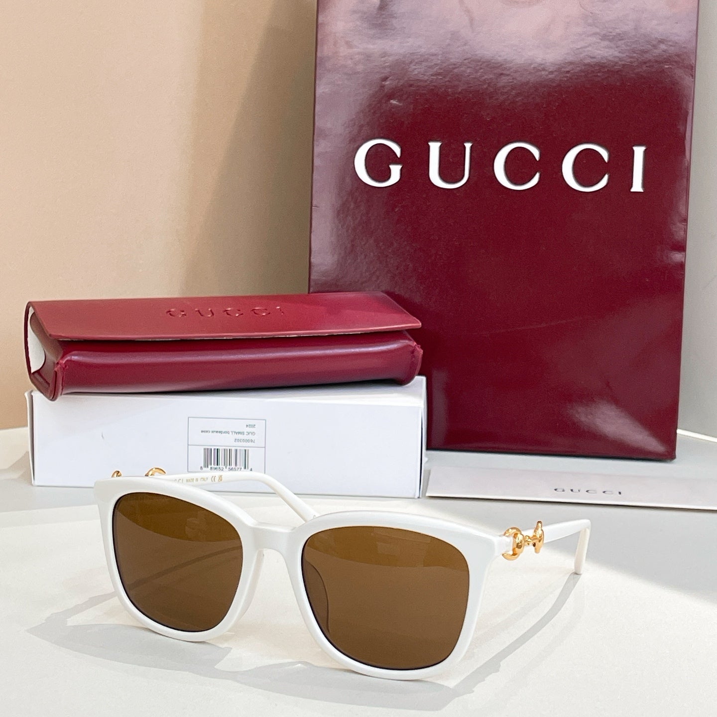 Gucci sunglasses with white frames and tan-brown tinted lenses