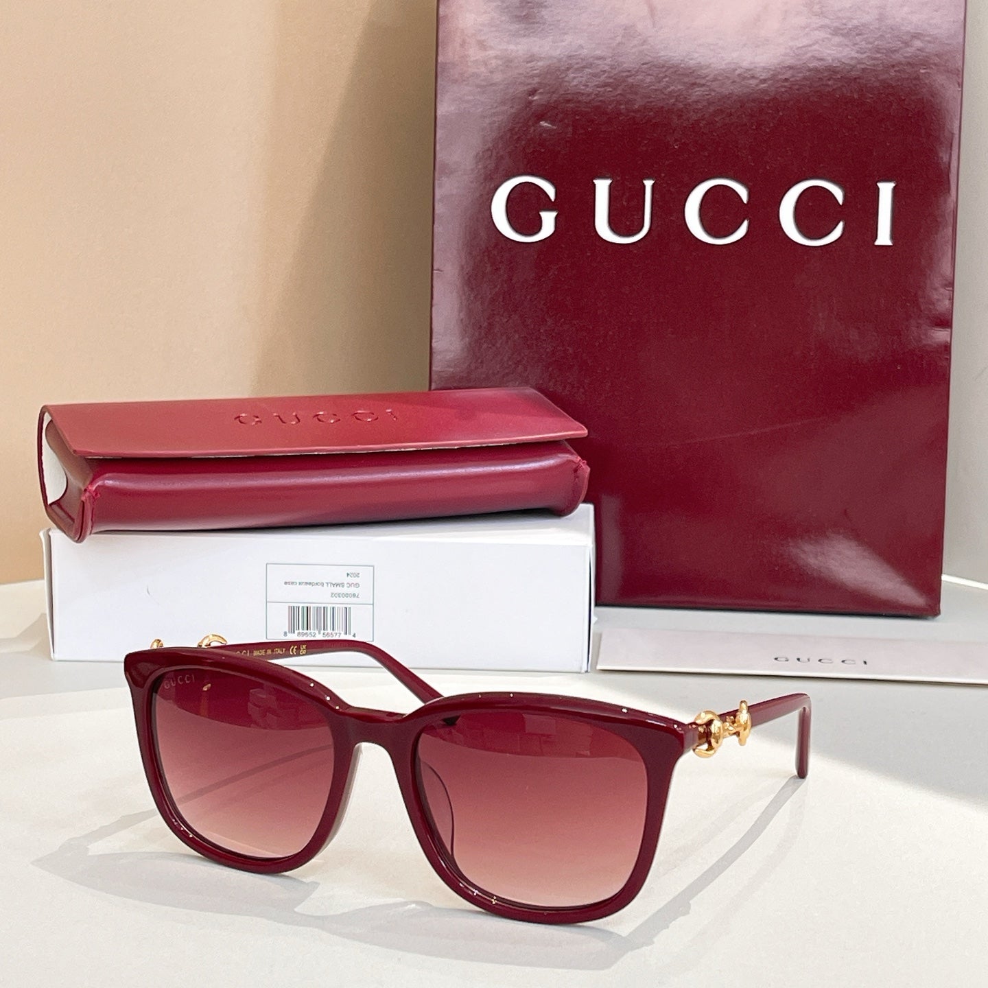 Gucci sunglasses with dark red frames and red-tinted lenses