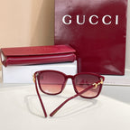 Gucci sunglasses with maroon frames and rose tinted lenses, gold accents and logo
