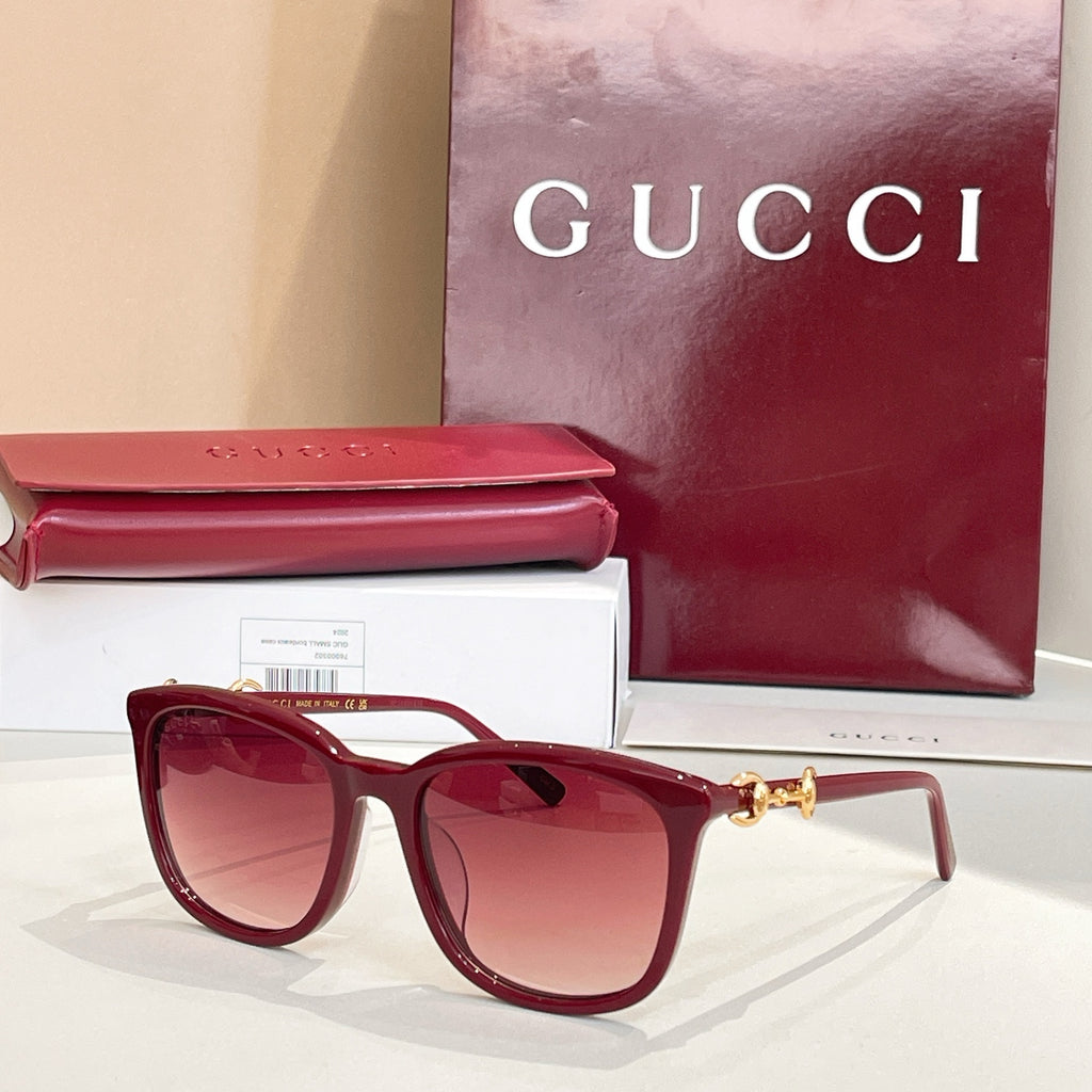 Gucci sunglasses front view with maroon frames, rose tinted lenses, and gold bridge