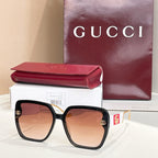 Black square sunglasses with brown gradient lenses and gold logo accents