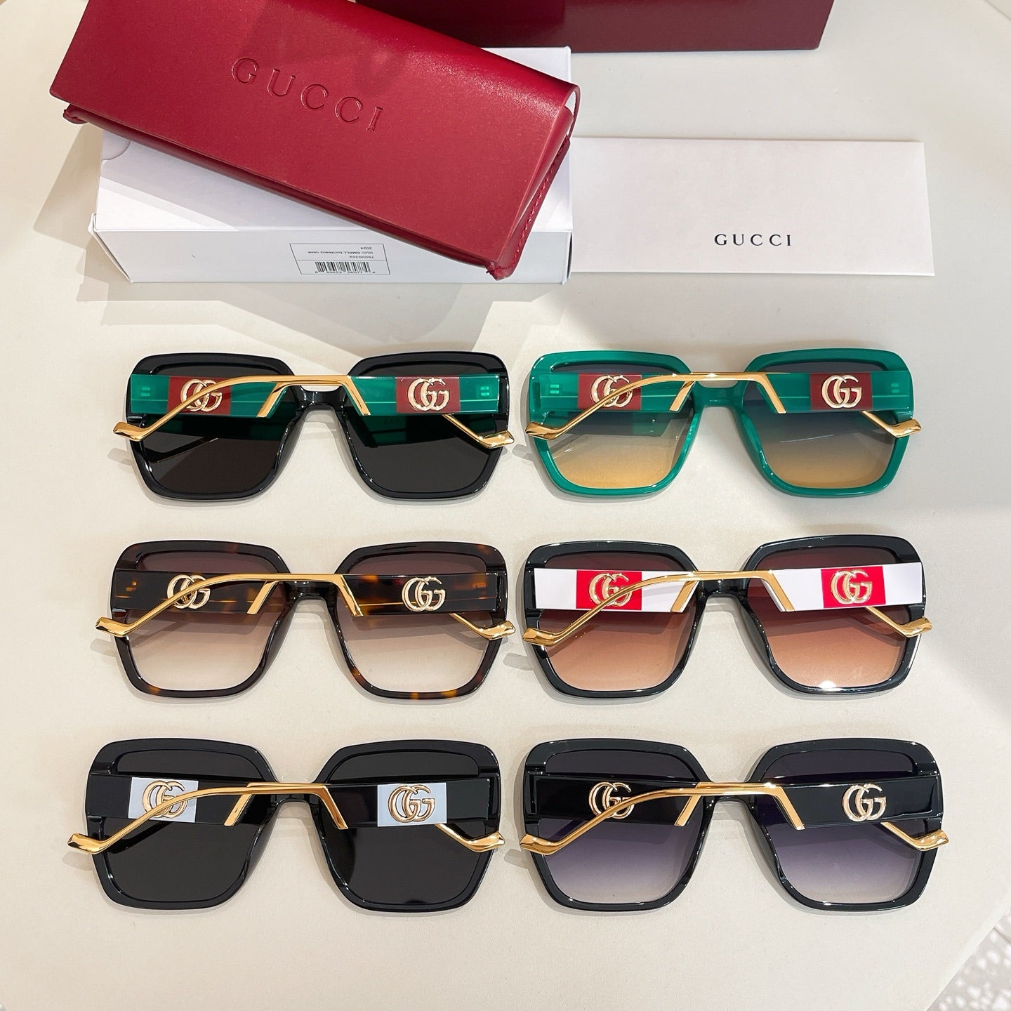 Group of square sunglasses with gold trims in teal, black, and tortoiseshell colors