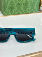 Gucci sunglasses with teal blue frames and dark rectangular lenses
