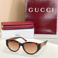 Gucci cat-eye sunglasses with dark tortoise frames and warm brown lenses