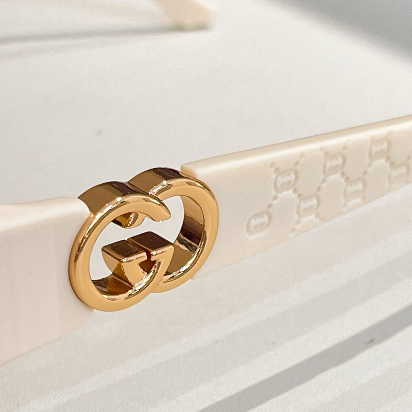 Gucci gold GG emblem on sunglasses temple with light frame