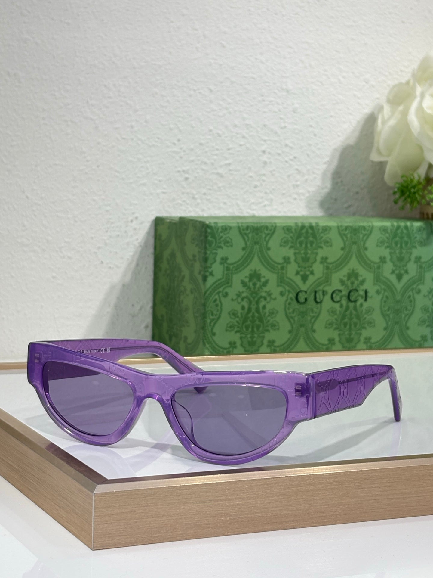 Glasses with purple frames and dark tinted lenses