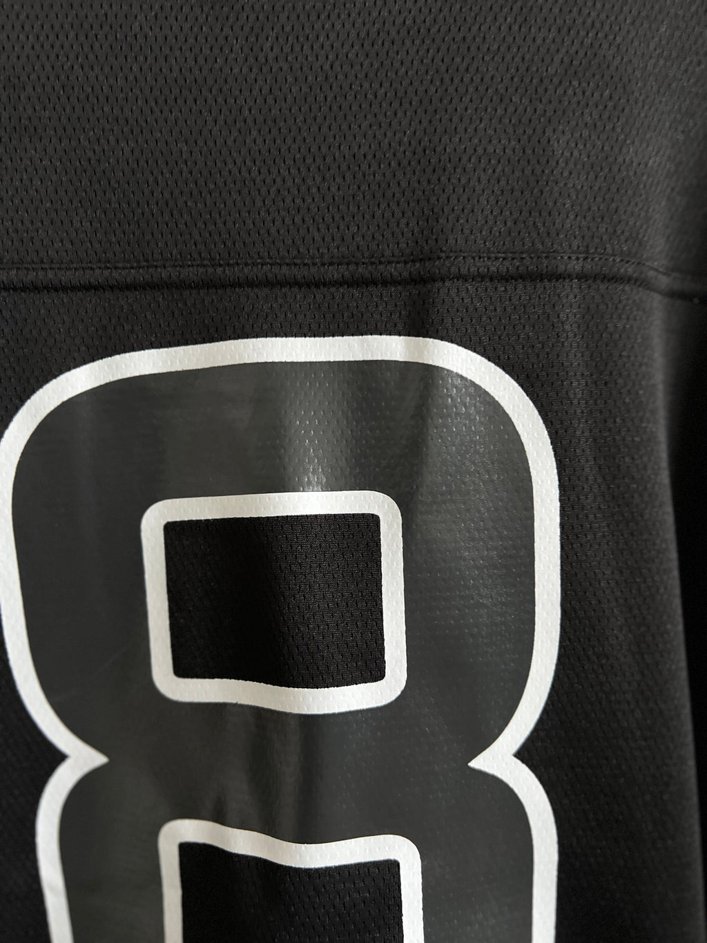 Balenciaga black T-shirt close-up of white "8" outline logo on chest