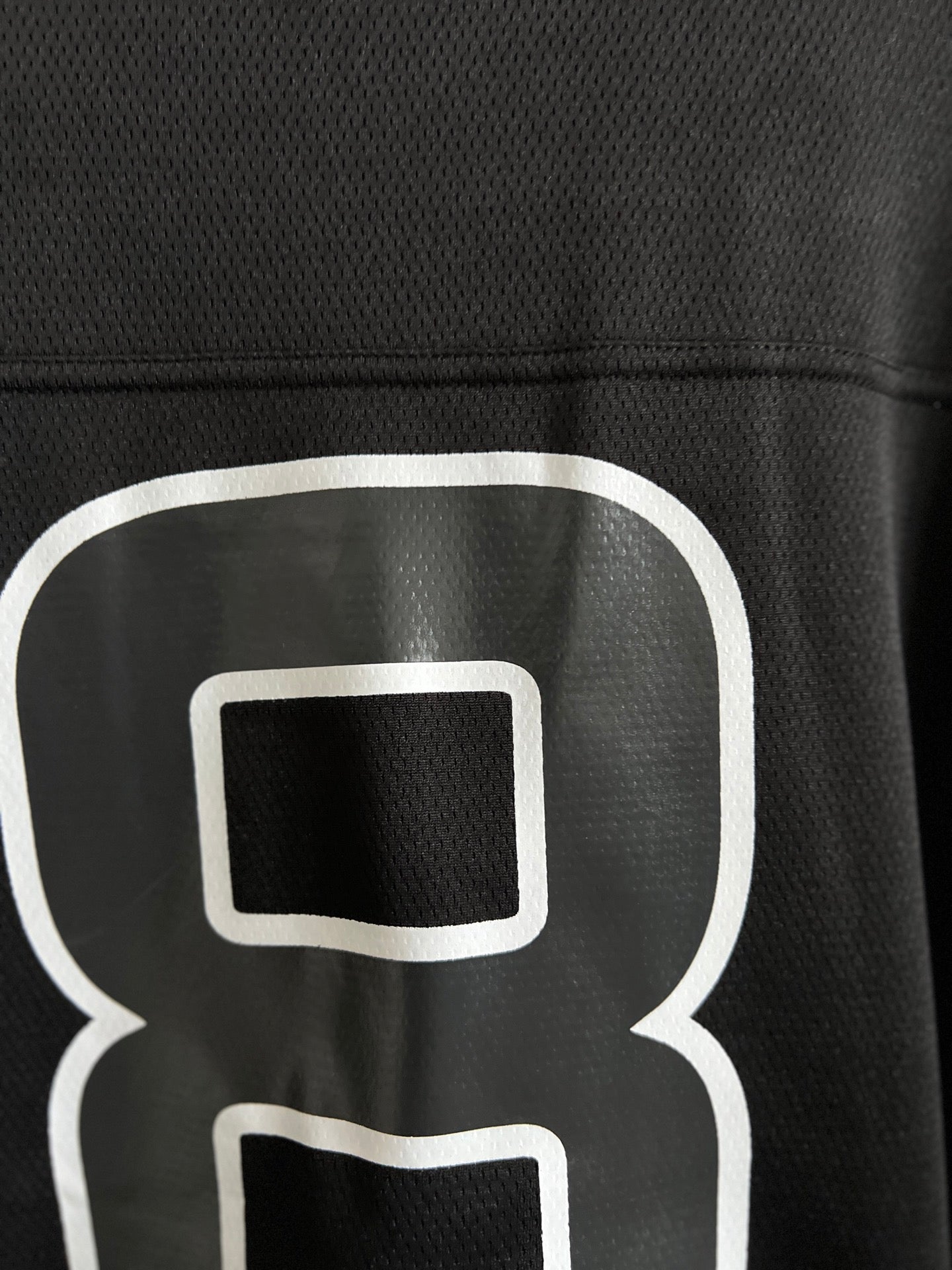 Balenciaga black T-shirt close-up of white "8" outline logo on chest