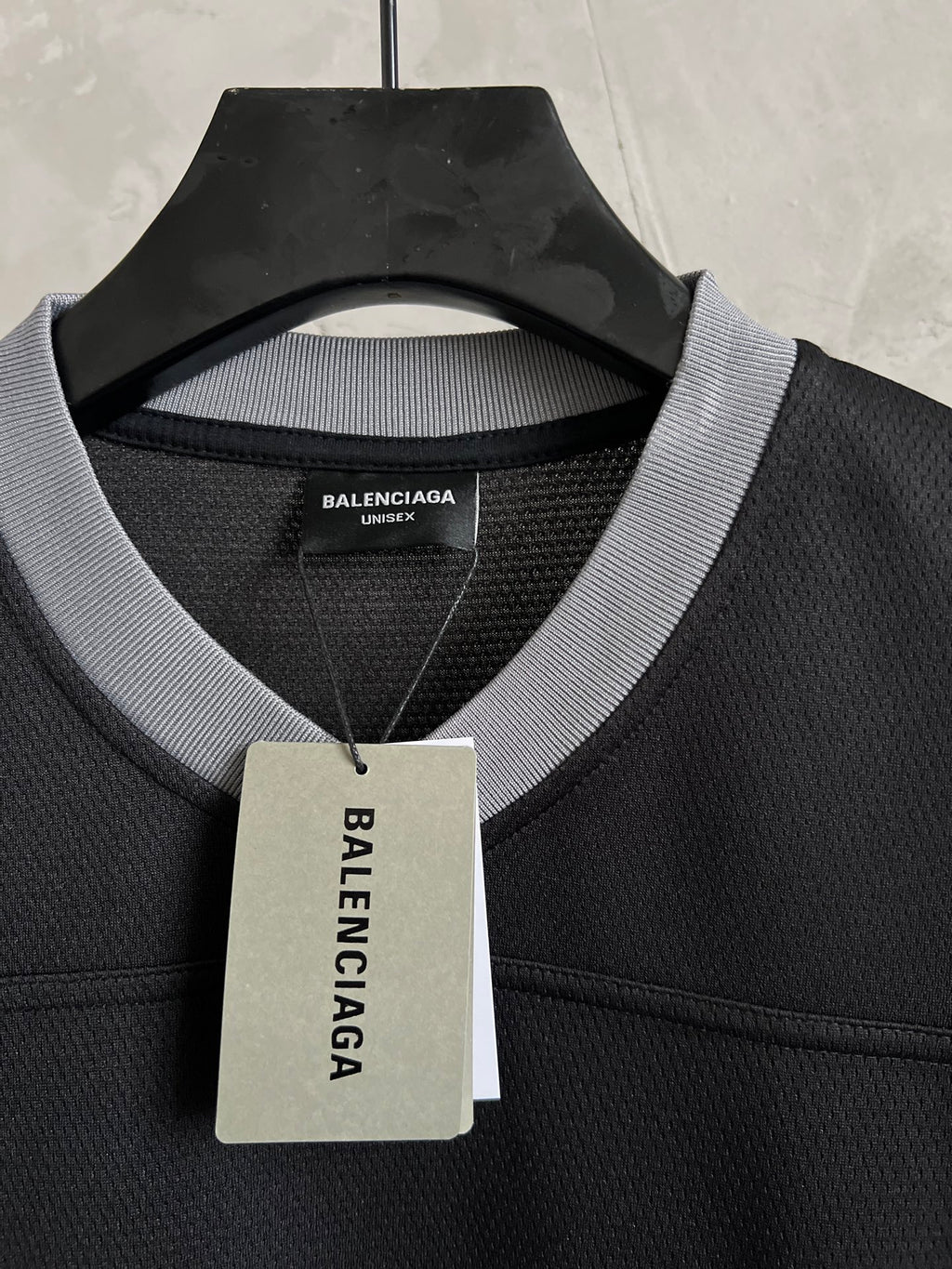 Balenciaga black T-shirt collar with Unisex label tag hanging from neckline