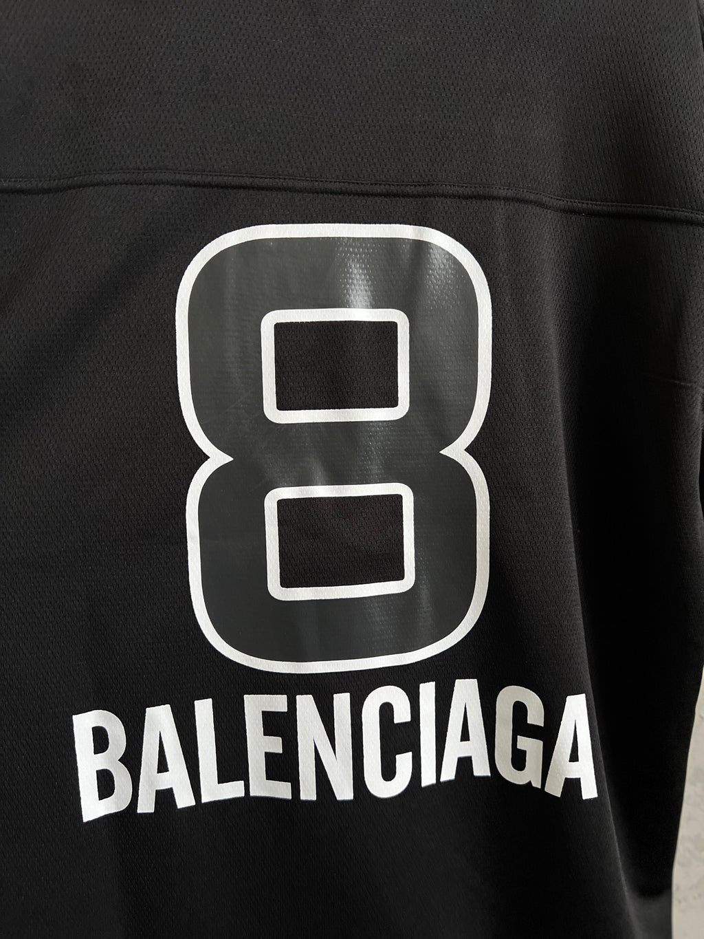 Balenciaga black T-shirt close-up of white "8" logo and BALENCIAGA