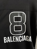 Balenciaga black T-shirt close-up of white "8" logo and BALENCIAGA