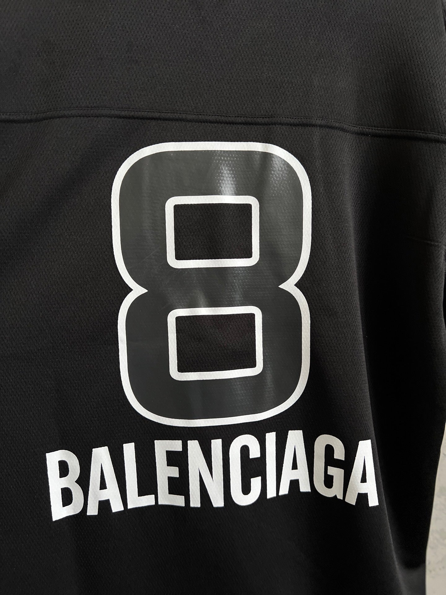 Balenciaga black T-shirt close-up of white "8" logo and BALENCIAGA