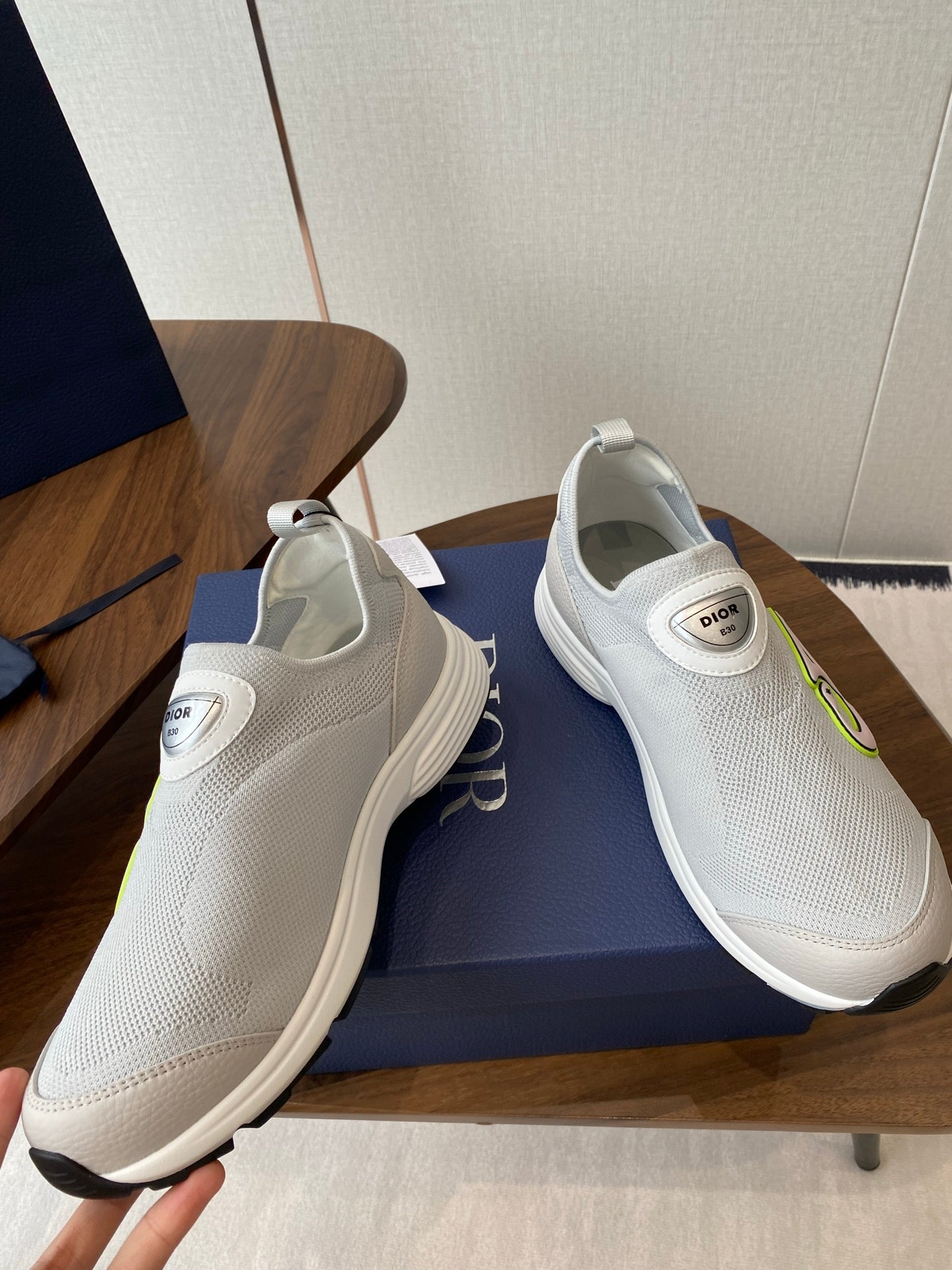 Unisex white slip-on sneakers with green logo, shown from side and top