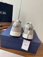 Unisex white slip-on sneakers with green logo on back, two shoes shown rear view