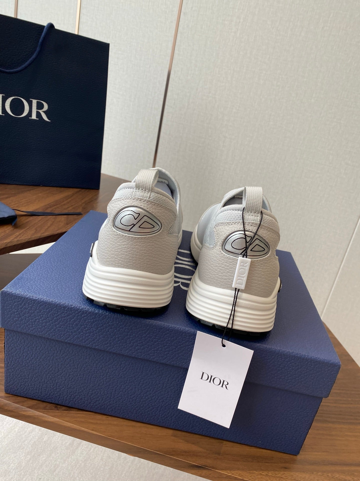Unisex white slip-on sneakers with green logo on back, two shoes shown rear view