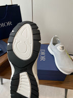 Unisex white slip-on sneakers showing treaded outsole and DIOR logo on heel