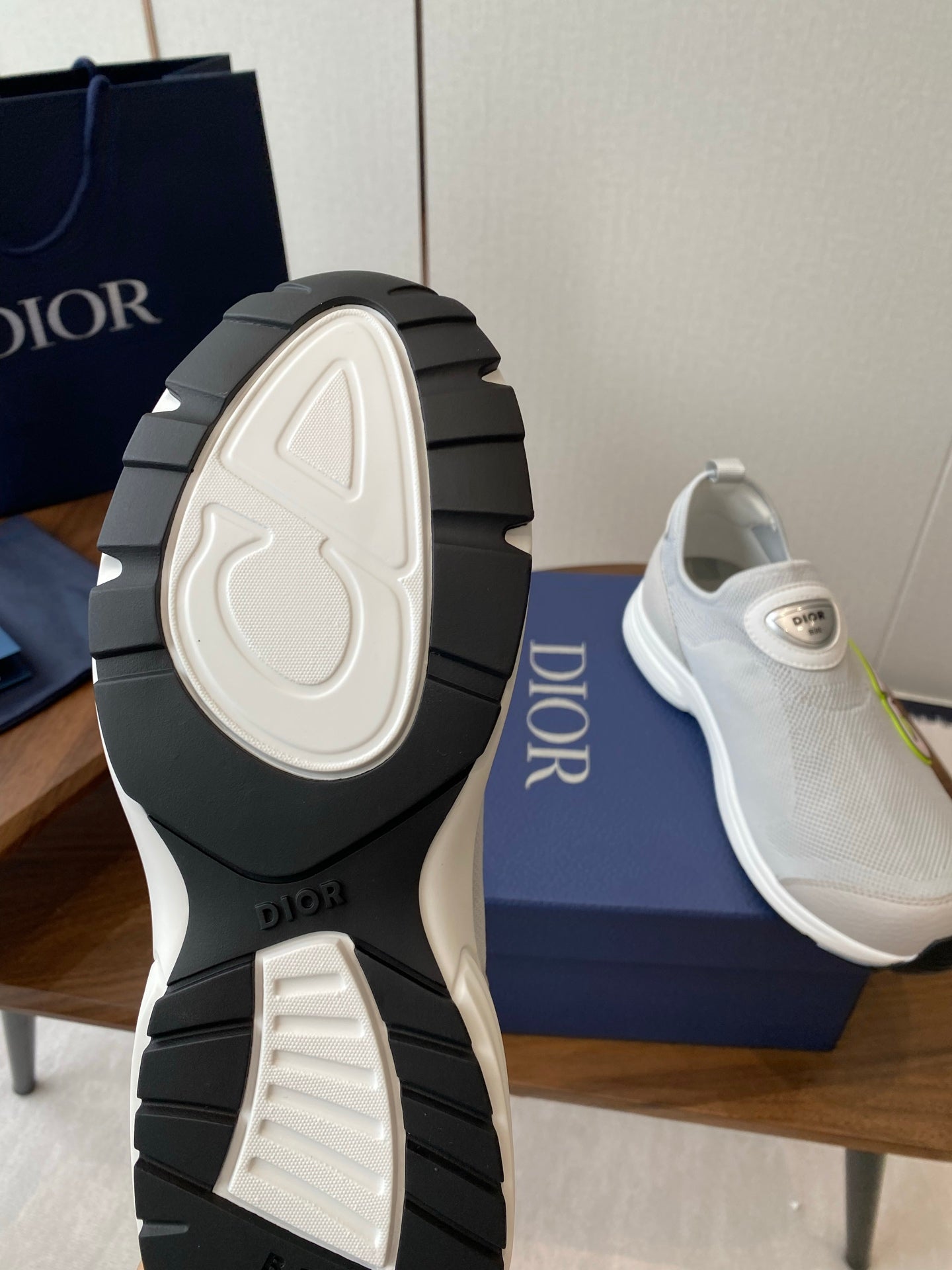 Unisex white slip-on sneakers showing treaded outsole and DIOR logo on heel