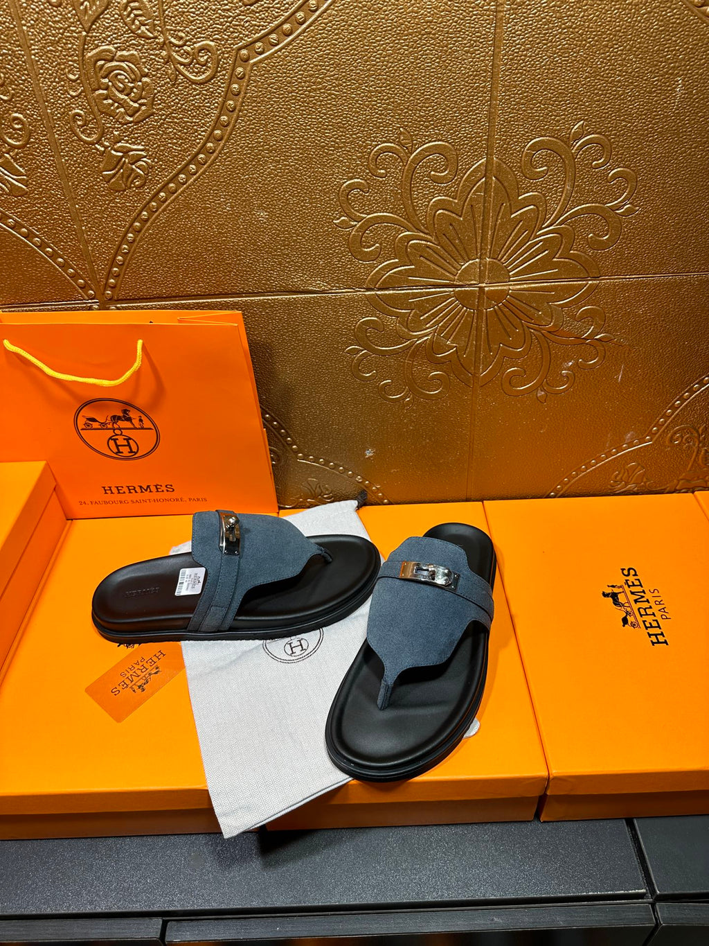 Hermes sandals with blue suede straps and silver buckle, pair shown on display