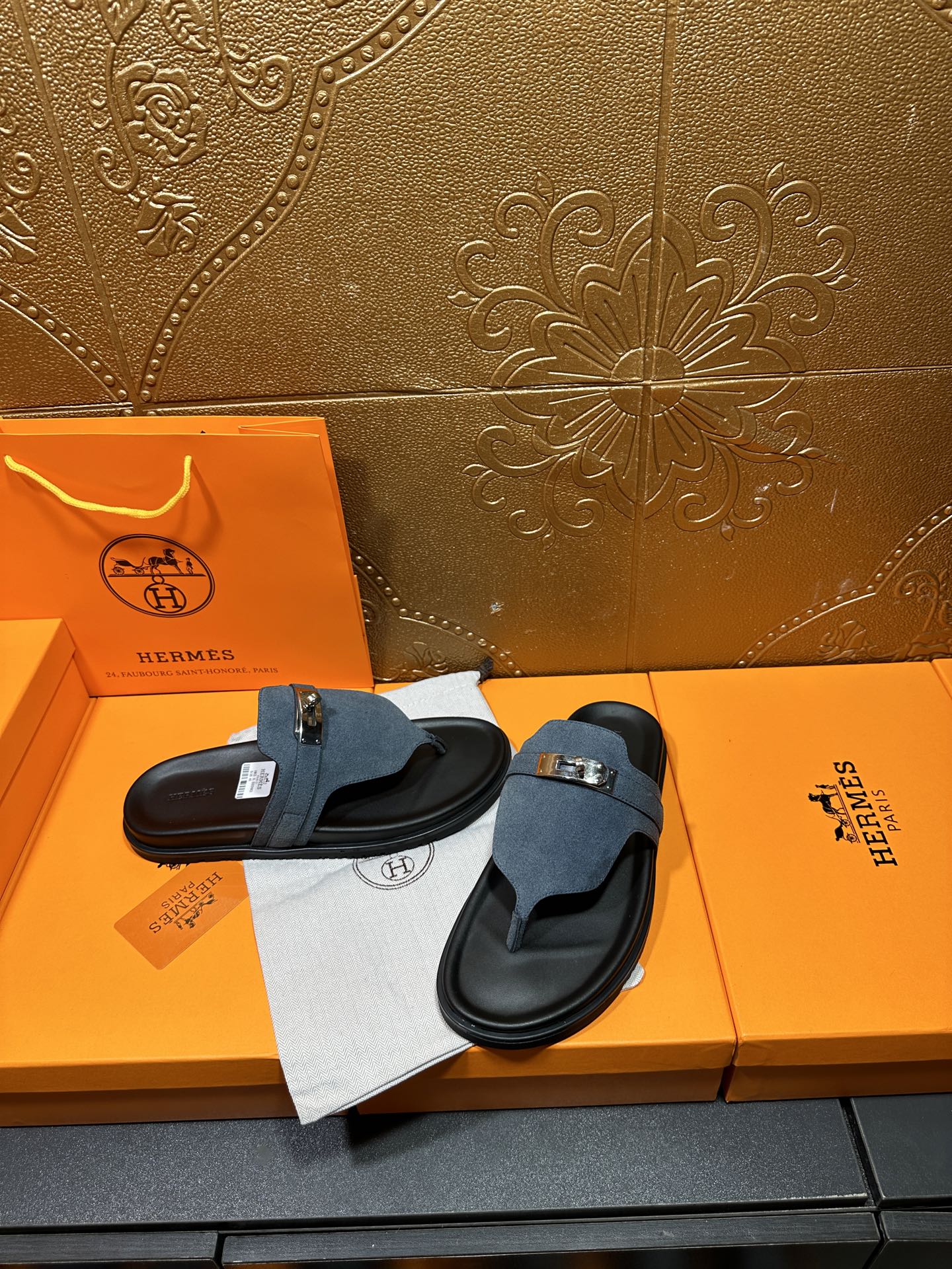 Hermes sandals with blue suede straps and silver buckle, pair shown on display