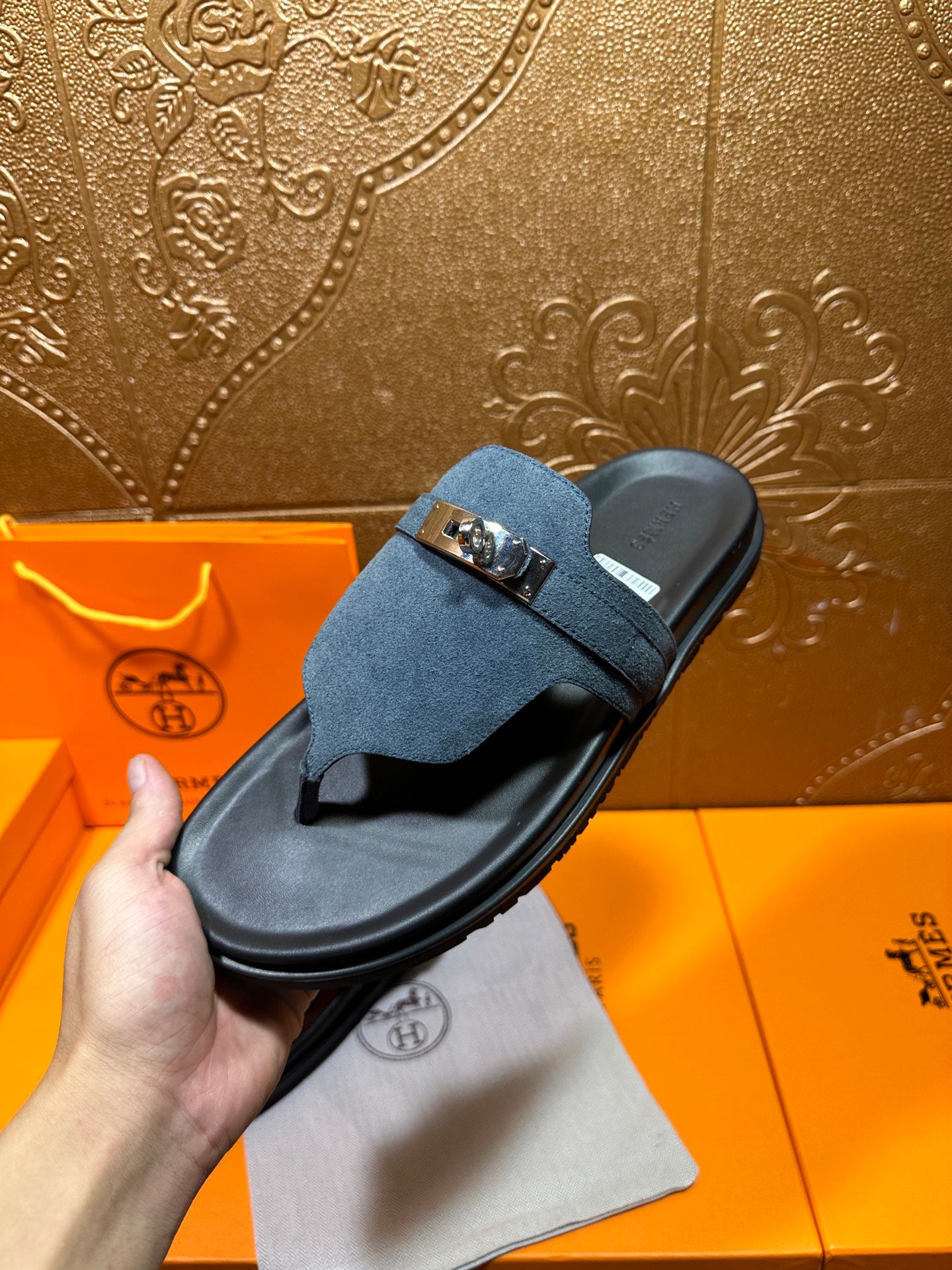 Hermes sandal on hand: blue suede strap with silver buckle over black sole