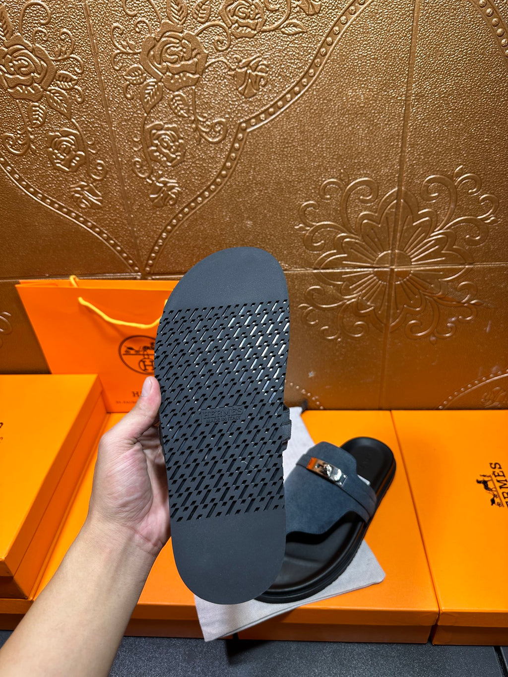 Hermes sandals, view of textured black outsole with blue upper and silver buckle