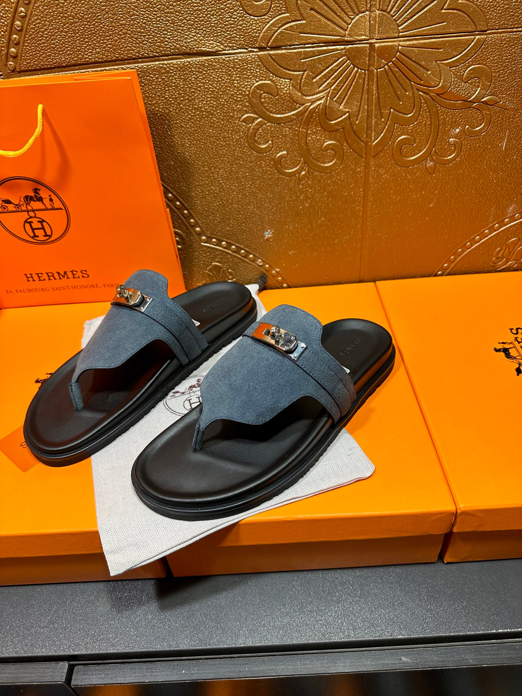 Hermes slide sandals, blue suede with silver buckle, shown from side angle