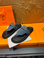 Hermes slide sandals, blue suede with silver buckle, shown from side angle