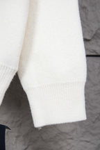 White ribbed hem and cuff detail on long-sleeve knit sweater