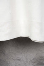 White ribbed knit hem with curved edge on sweater