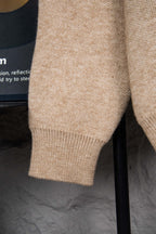 Beige knit sweater sleeve cuff with ribbed hem detail