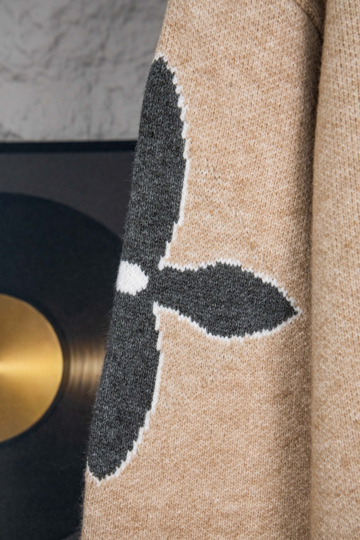 Beige knit sweater sleeve with dark vertical LV graphic