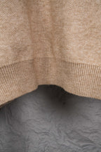 Beige knit sweater bottom hem with ribbed trim detail