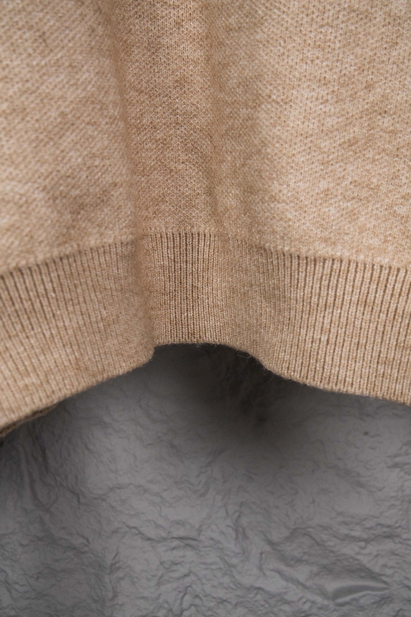 Beige knit sweater bottom hem with ribbed trim detail
