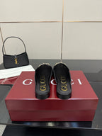 Gucci black slip-on mules with logo print on the heel and gold-toned hardware