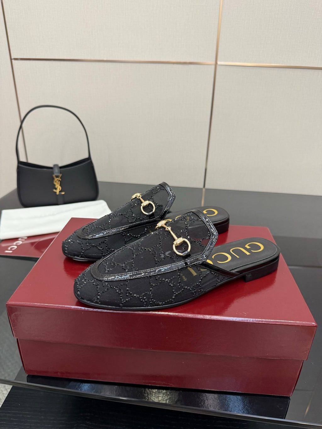 Gucci black horsebit mule with gold hardware and embossed pattern on the upper