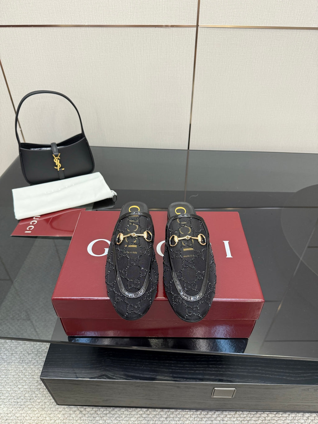 Gucci black horsebit mules with gold-toned buckle detailing and embossed pattern