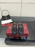Gucci black horsebit mules with gold-toned buckle detailing and embossed pattern