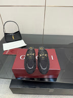 Gucci black horsebit mules with gold-toned buckle detailing and embossed pattern