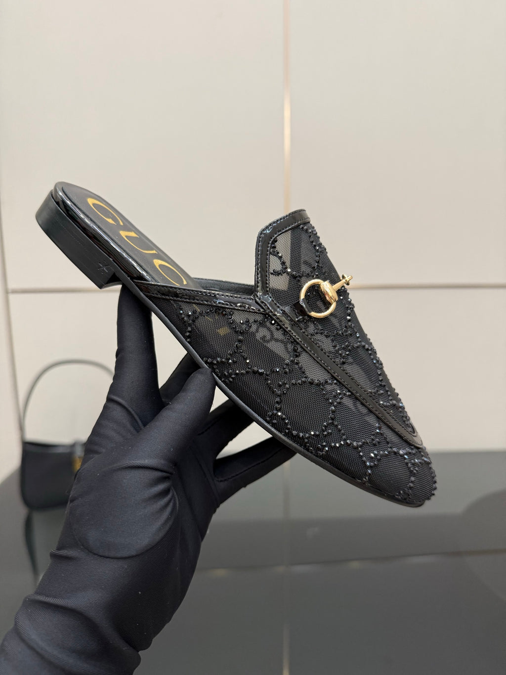 Gucci black horsebit mule with gold-tone ring bit and embossed leather pattern